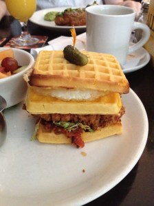 kfc-style chicken breast, bacon marmalade, fried egg, cheddar, frisée. cornichons, creole mustard on toasted waffles with fruit salad